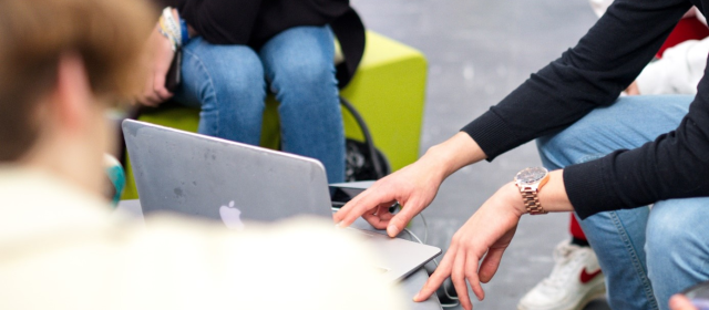 Étudiants assis autour d'un ordinateur portable